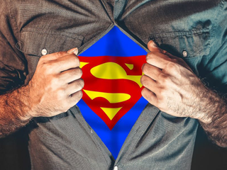 Un homme entrouve sa chemise dévoilant un S sur son torse comme le fait Superman